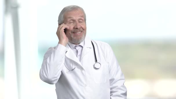 Пожилой врач разговаривает по телефону . — стоковое видео