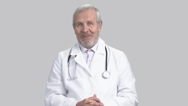 Dottore che parla con la macchina fotografica, sfondo grigio . — Video Stock