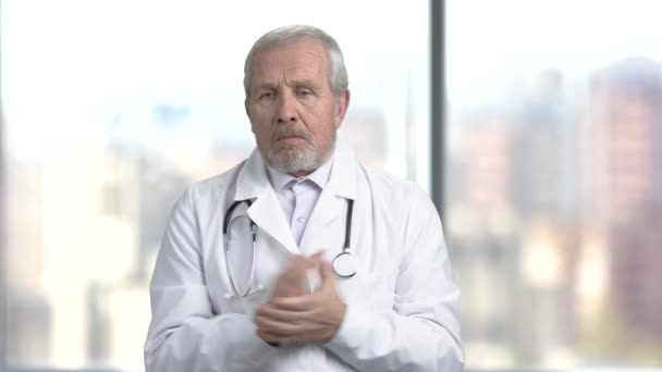 Confused senior doctor, blurred background. — Stock Video