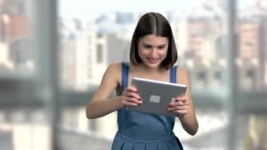 Sevimli kadın PC tablet üzerinde oynama. Heyecanlı kadın bilgisayar tablet üzerinde oyun oynarken arka plan bulanık. İnsanlar, teknoloji, eğlence.