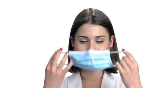 Close-up van jonge verpleegster zetten masker. — Stockvideo