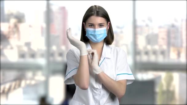 Жінка-медик одягає рукавички . — стокове відео