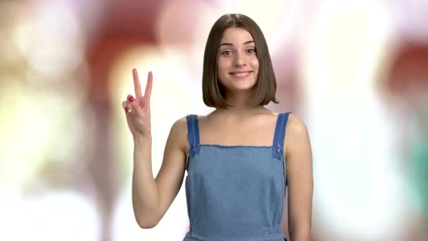 Молодая очаровательная женщина показывает два пальца . — стоковое видео