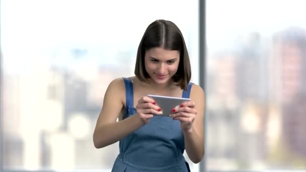 Heureuse femme émotionnelle jouant sur smartphone . — Video