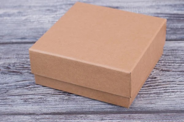 Brązowy pudełko na drewniane tła. — Zdjęcie stockowe