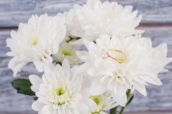 Diamond ring on white flowers.