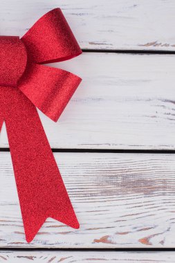 Beyaz ahşap plakalar üzerinde kırmızı Noel yay.