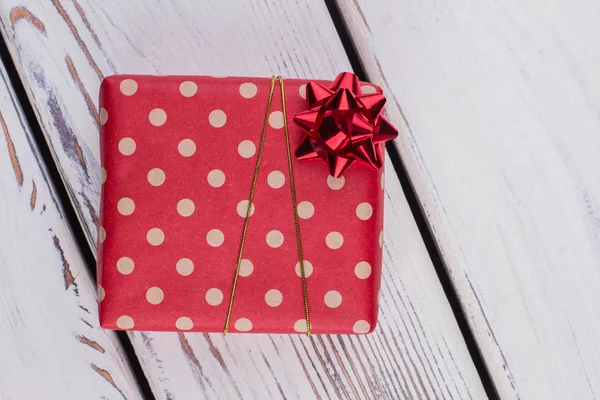Karácsonyi ajándék csomagolva a piros pöttyös papír. — Stock Fotó
