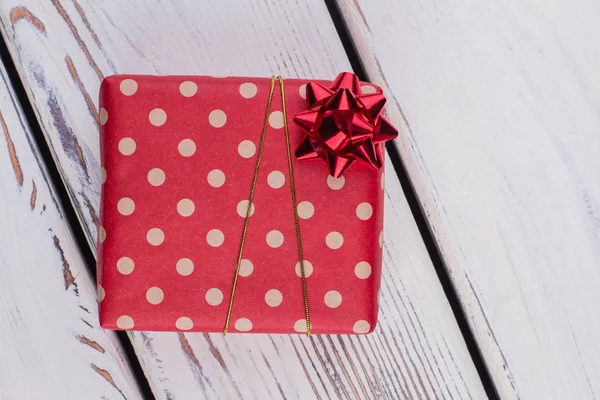 Regalo de Navidad envuelto en papel punteado rojo . —  Fotos de Stock