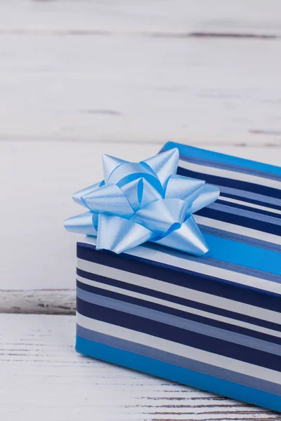 Beyaz zemin üzerine mavi çizgili hediye kutusu. — Stok fotoğraf