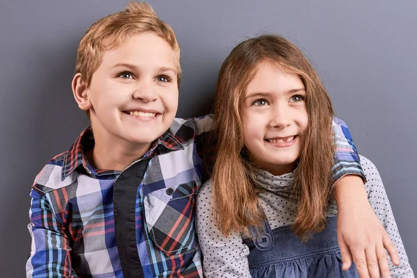 Little brother smiling and hugging sister.