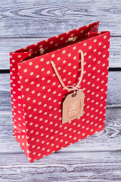 Saco de compras vermelho na mesa de madeira . — Fotografia de Stock