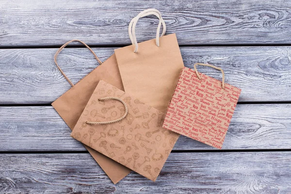 Kraft paper shopping bags on wooden background. — Stock Photo, Image