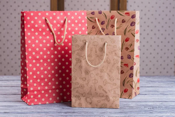 Three kraft paper gift bags with printing. — Stock Photo, Image