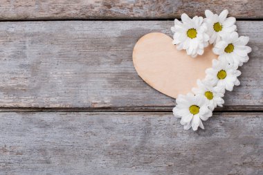 Beyaz papatya çiçekler bileşimi ile ahşap kalp.