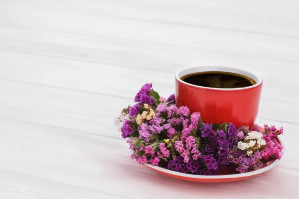 Café rouge et fleurs de limonium statice . — Photo