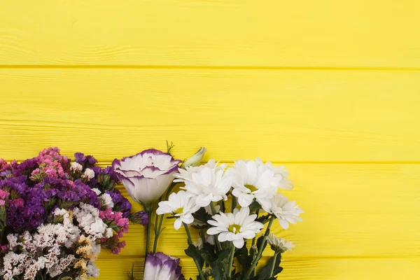 Διαφορετικά λουλούδι ανθοδέσμες σε κίτρινο ξύλο. — Φωτογραφία Αρχείου