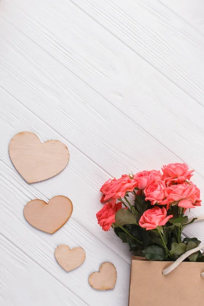 Hermosas rosas y corazones de madera . — Foto de Stock