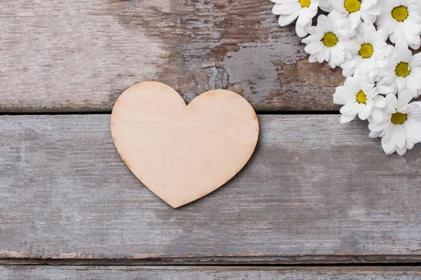 Corazón de madera y flores blancas . —  Fotos de Stock