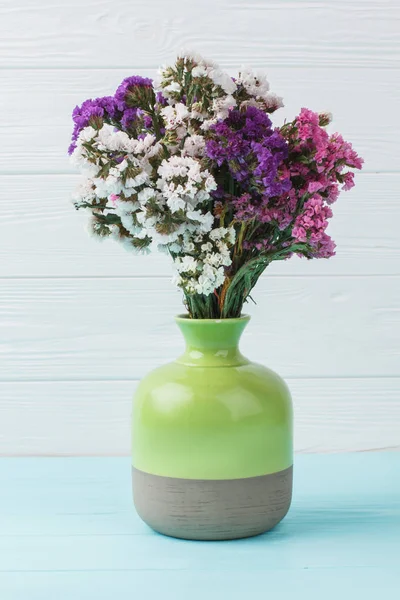 Green ceramic vase with colorful statice limonium flowers. — Stock Photo, Image