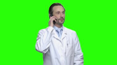 Olgun beyaz doktor büyük bir ruh halinde telefonda konuşuyor.