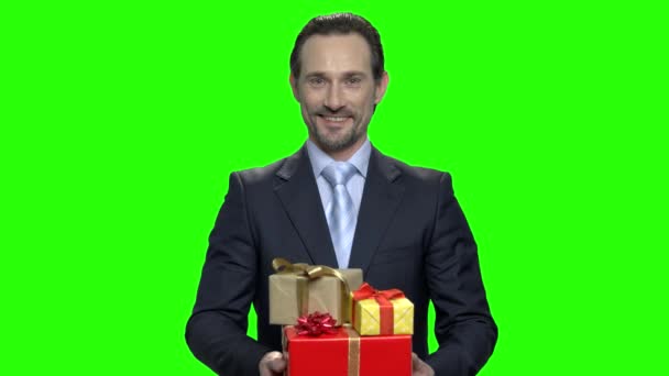 Fröhlicher Mann im Business-Anzug mit Geschenkschachteln. — Stockvideo