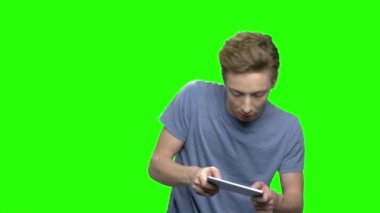 Duygusal çocuk video oyunları oynamak. Onun smartphone üzerinde oyunlar zevk genç genç çocuk portresi. Yeşil ekran hromakey arka plan tuşlama için.