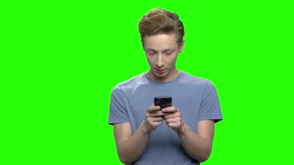 Knappe jonge tiener jongen bericht aan het typen op smartphone. — Stockvideo