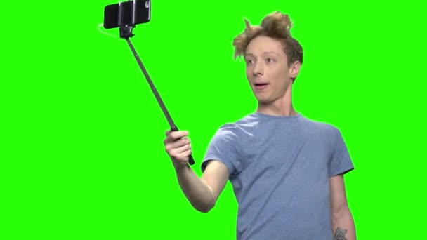 Young teenage boy taking selfie with selfie stick. — Stock Video