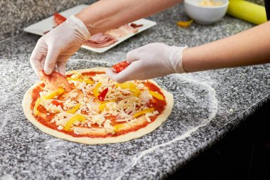 Domates dilimleri pizza koyarak Şef.