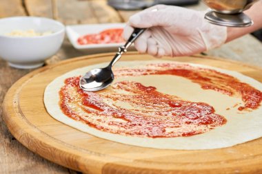 Şef el kadar pizza kabuk bulaşması kaşıkla kapatın.