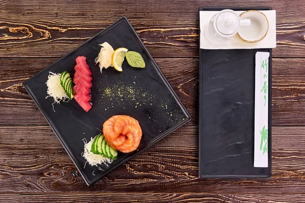 Restaurante servido nigiri sushi, plato de salsa y palillos envueltos . — Foto de Stock