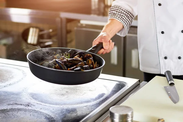 Stekning skal musslor i pannan. — Stockfoto