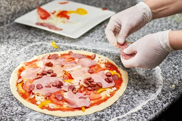 Şef pizza için salam dilimlerini ekleyeyim.