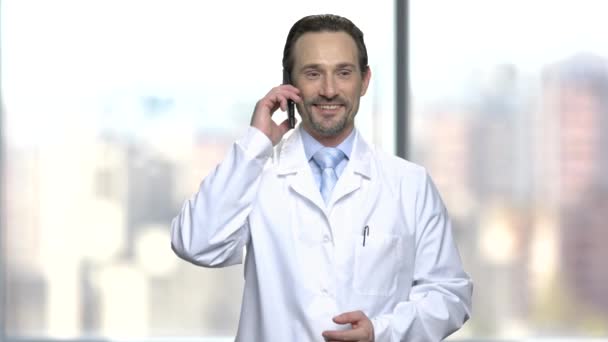 Opgewonden man in witte jas praten over telefoon. — Stockvideo