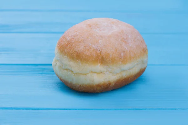 Donut recém-assado em fundo de madeira azul . — Fotografia de Stock