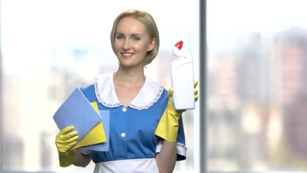 Jolie femme de chambre souriante tenant des fournitures de nettoyage . — Video
