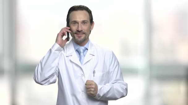 Tevreden mannelijke arts praten over telefoon. — Stockvideo
