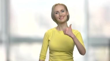 Mutlu sarışın kadın el hareketi yapıyor..