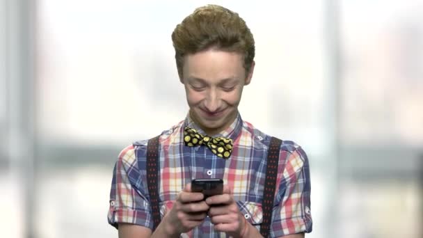 Χαμογελαστός τύπος έφηβος χρησιμοποιεί το κινητό του. — Αρχείο Βίντεο
