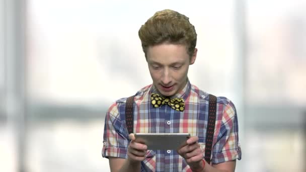 Snygg tonåring pojke spelar spel på smartphone. — Stockvideo