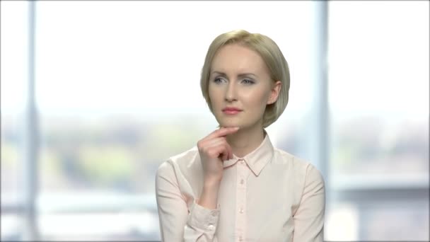 Thoughtful business woman on blurred background. — Stock Video