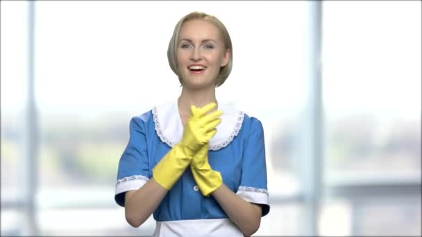 有吸引力的女服务员在模糊的背景 美丽的家庭主妇在黄色手套微笑着看着相机 模糊的窗口背景 — 图库视频影像