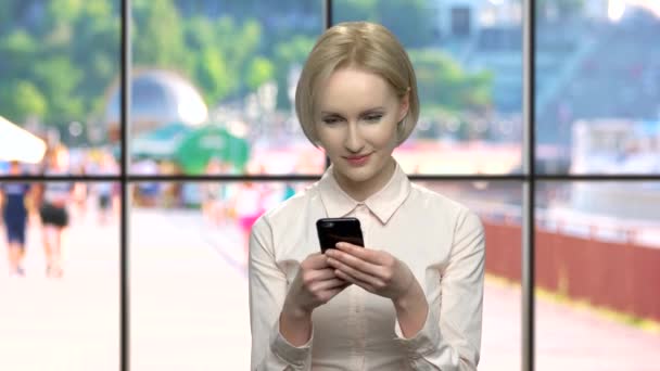 Mujer de oficina bastante sonriente usando teléfono móvil . — Vídeos de Stock