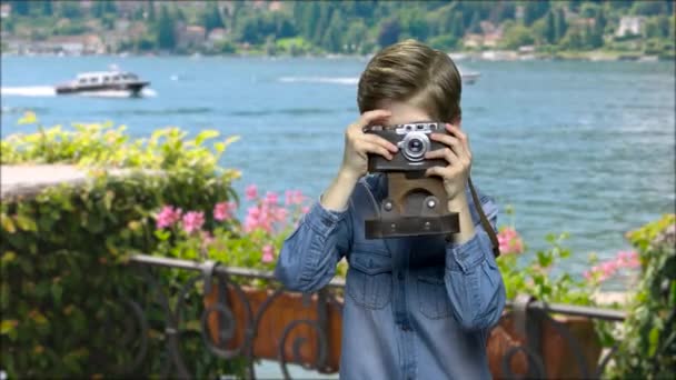 Little boy using film camera on sea background. — Stock Video