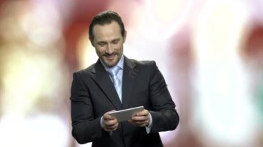 Onun smartphone oyun heyecanlı orta yaşlı işadamı.