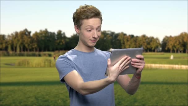 Atractivo adolescente usando PC tableta al aire libre . — Vídeos de Stock