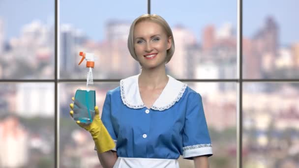 Sorrindo empregada doméstica segurando spray de limpeza . — Vídeo de Stock
