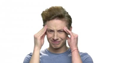 Ergen migren muzdarip erkek. Onun tapınakları güçlü ağrıdığı masaj teen yakışıklı olan. Beyaz arka plan üzerinde izole.