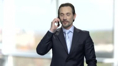 Cep telefonuyla konuşurken olgun sakallı işadamı.